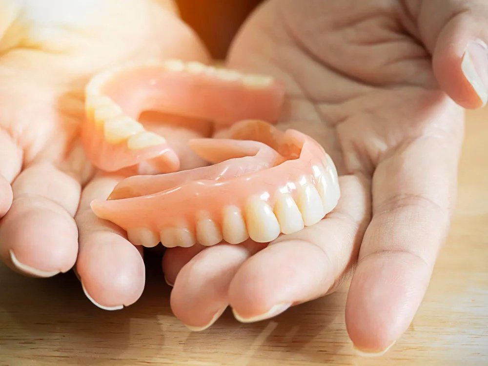 Hands holding dentures